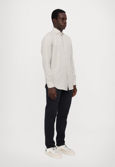 Light gray checkered button-up shirt, long sleeves, collar, paired with navy pants and white sneakers. Smooth fabric, tailored fit.