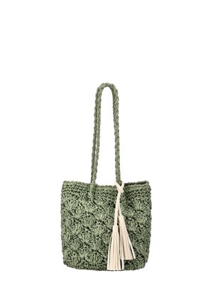 Zöld szőtt bevásárlótáska fonott fogantyúkkal és két bézs bojttal, amelyek az egyik fogantyúról lógnak, fehér háttér előtt.