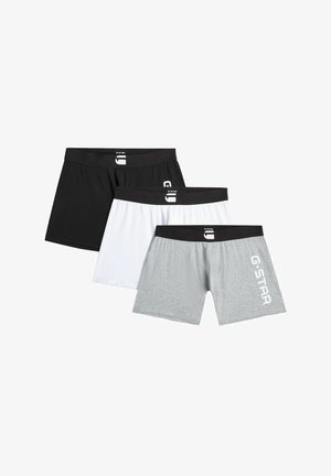 Drei Herren-Boxershorts in Schwarz, Weiß und Grau mit schwarzen Taillenbändern; das graue Paar trägt das "G-STAR"-Logo am linken Oberschenkel.