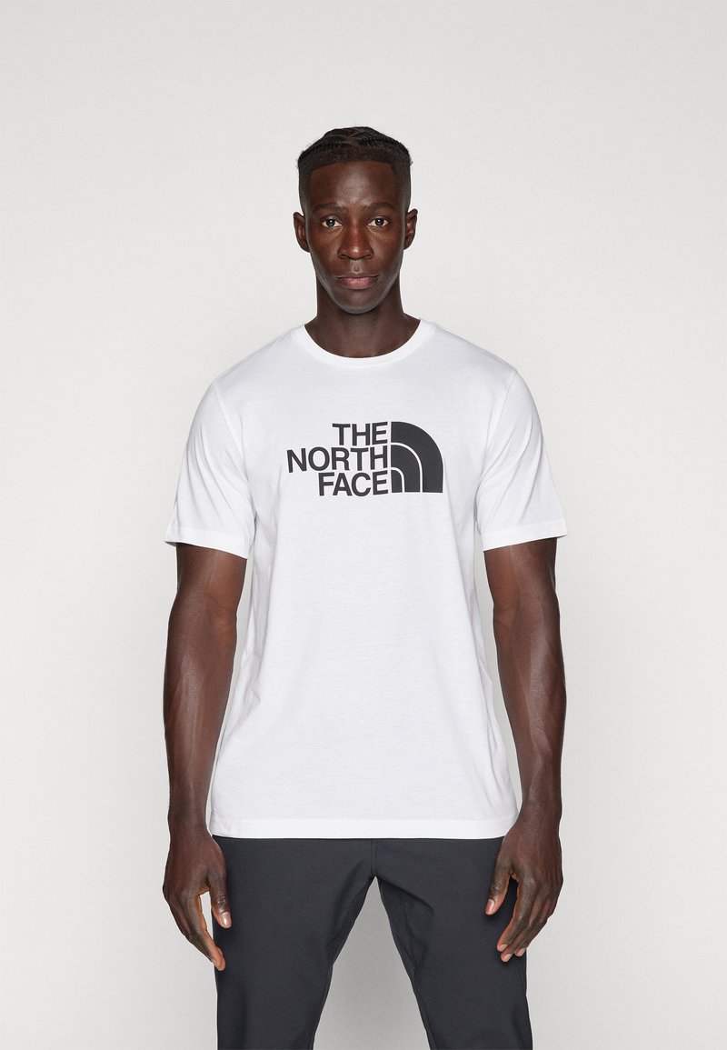 Hvit bomulls t-skjorte med "THE NORTH FACE" i fet sort skrift og en buet logo, rund hals og korte ermer.