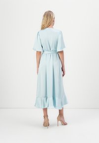 Vestido azul claro de satin com mangas curtas e bufantes, faixa na cintura e bainha com franzido. Projetado para uma silhueta de comprimento médio.