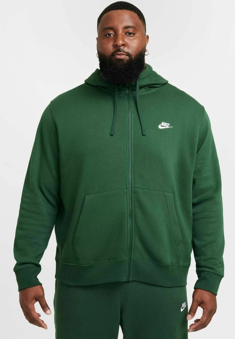 Grön zip-up hoodie i mjukt tyg, med framficka och justerbar dragkedja på huven. Nike-logotyp i vitt på bröstet.