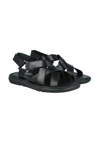 Sandalias de cuero negro con correas entrecruzadas, punta abierta y suela negra acolchada. El diseño ofrece una estructura ligera y flexible.