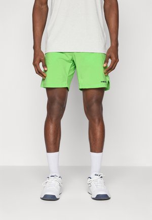 Green athletic shorts made of lightweight fabric. Features an elastic waistband and a logo at the hem. Paired with white socks and shoes.