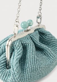 Pequeño bolso tejido en tonos verde azulado con marco metálico plateado, cierre redondo en tono verde azulado y correa de cadena plateada.
