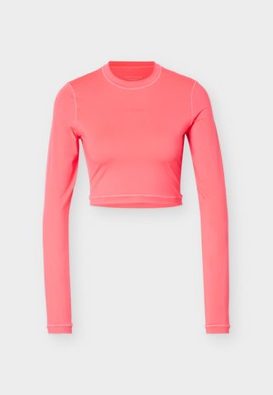 Top corto a maniche lunghe di un vivace rosa corallo con scollo tondo e dettagli sottili sulle cuciture, su uno sfondo chiaro e uniforme.