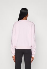 Lys rosa sweatshirt med rund hals, ribbet kant og nedtrukne skuldre. Mykt materiale med lange ermer og minimalt med detaljer.