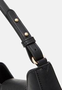 Pasek do torebki z czarnej skóry z akcentami złotego okucia, posiadający teksturowaną powierzchnię i widoczne przeszycia, prezentujący elegancki, usztywniony design.