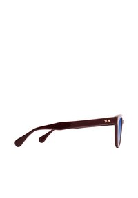 Gafas de sol con montura de plástico de color marrón oscuro, lentes de color azul y patillas anchas y elegantes que presentan un acento geométrico en el lateral.
