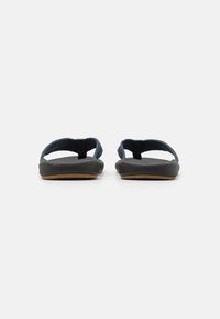 Mørkeblå flip-flops med teksturerte stropper, en svart gummisåle og en brun såle. Enkelt design uten dekorasjoner.