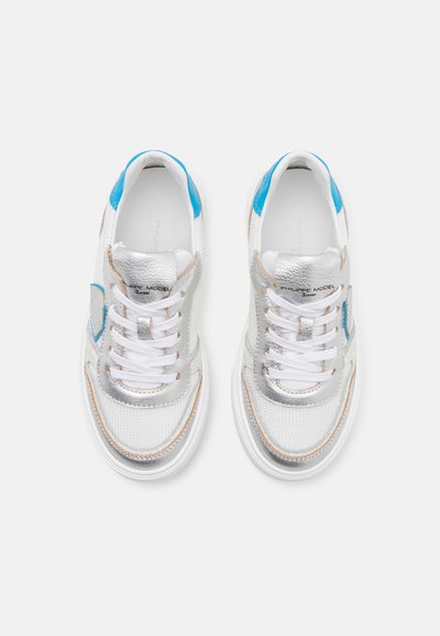 Silberne Netzsneaker mit blauen Akzenten und metallischen Details. Verfügt über weiße Schnürsenkel, eine abgerundete Zehenpartie und eine gepolsterte Sohle. Minimalistisches Design.