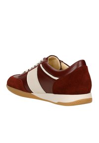 Baskets basses rouge et blanche avec un mélange de cuir lisse et de daim, présentant une pointe arrondie, des lacets blancs et une semelle en caoutchouc gomme.