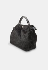 Borsa in pelliccia sintetica nera con una forma strutturata, dotata di una maniglia in pelle nera liscia e un sottile accento in metallo argentato.