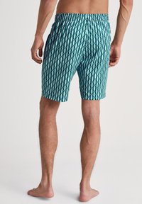 Heren zwembroek in teal met een diamantpatroon. Elastische tailleband, zijzakken en een ontspannen pasvorm voor comfort.