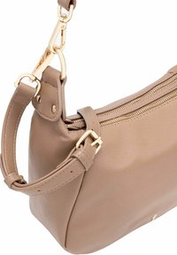 Torebka ze taupe skórki z regulowanym paskiem, złotym metalowym zapięciem, klamrą oraz zamknięciem na zamek na białym tle.