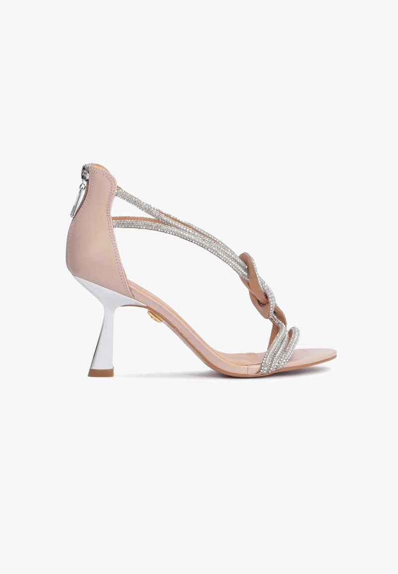 Μπεζ ψάθα με ψηλό τακούνι και πλεκτές ασημί λωρίδες, ανοικτού τύπου, με γυαλιστερό ασημί τακούνι και ελαφρώς καμπυλωτή σιλουέτα.