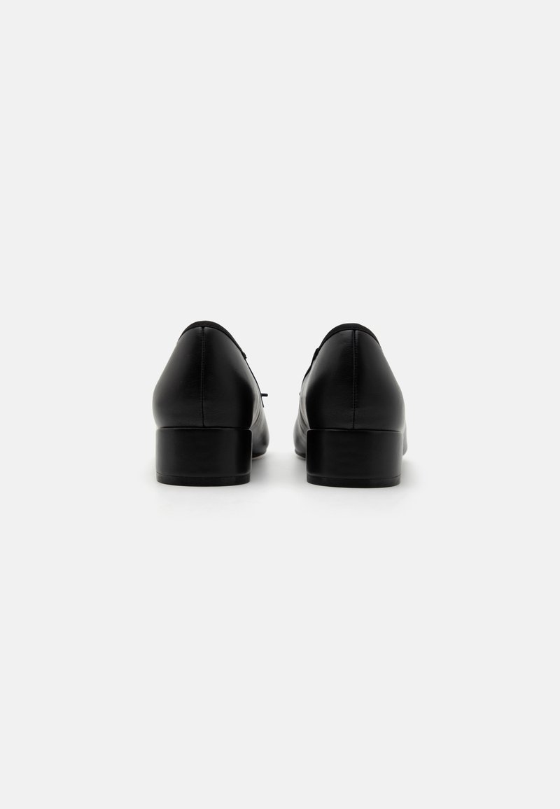 Chaussures en cuir noir avec une texture lisse, un bout rond et un petit talon carré, présentant des lignes épurées et un minimalisme dans le détail à l'arrière.