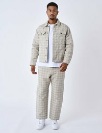 Vatteret beige denimjakke og matchende bukser med diamantmønster, parret med en hvid t-shirt og hvide sneakers.