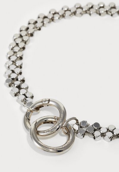Collier chaîne en métal argenté avec des perles rondes et un fermoir à double anneau, présentant une surface polie et réfléchissante.