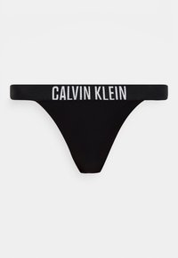 Μαύρο γυναικείο εσώρουχο τύπου σλιπ Calvin Klein με λευκό έντονο λογότυπο στη ελαστική μέση, σε απλό λευκό φόντο.