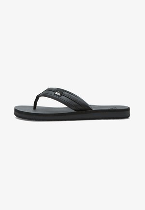 Sandale negre, cu un toc texturat, talpă plată și un detaliu subtil cu logo. Realizate din cauciuc și concepute pentru purtare casual.
