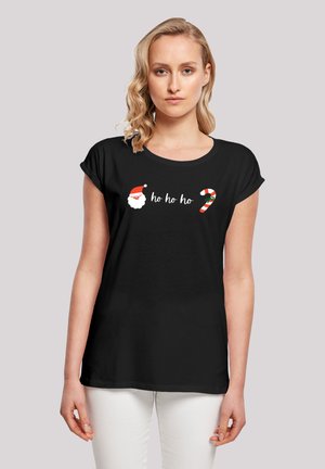 Camiseta negra de manga corta con el texto blanco "ho ho ho" y un gráfico de la cara de Papá Noel junto con un bastón de caramelo rojo y blanco.