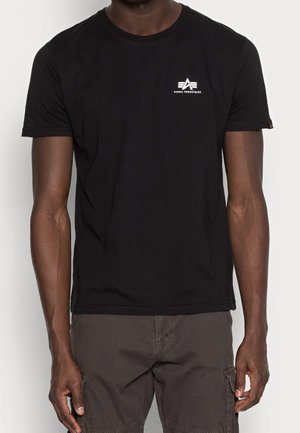 Schwarzes Baumwoll-T-Shirt mit kurzen Ärmeln, rundem Ausschnitt und einem kleinen weißen Logo auf der linken Brust. Glatte Textur, normale Passform.