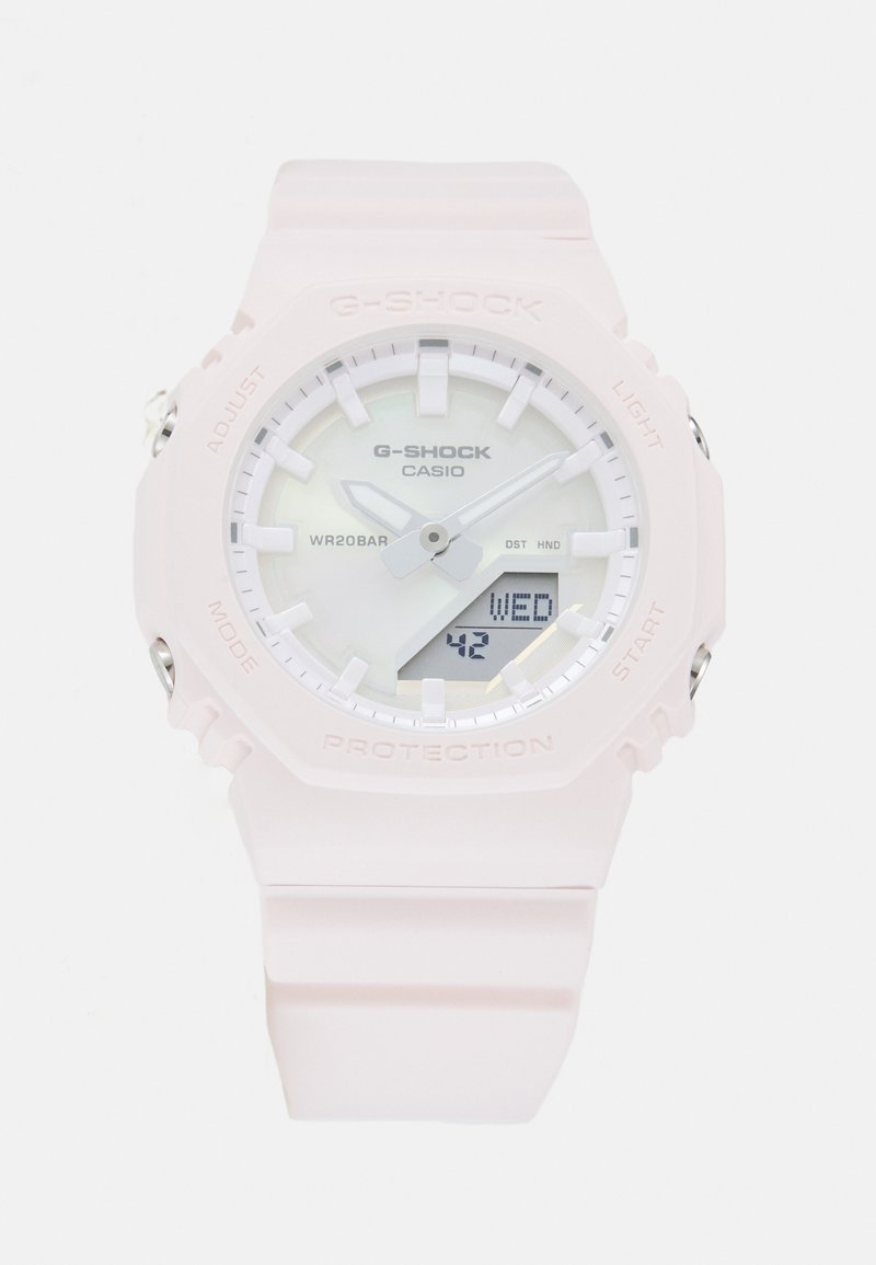 Montre G-SHOCK avec un bracelet en résine rose clair, cadran rond blanc, affichage analogique et numérique, étanche jusqu'à 20 bars, et accents en métal.