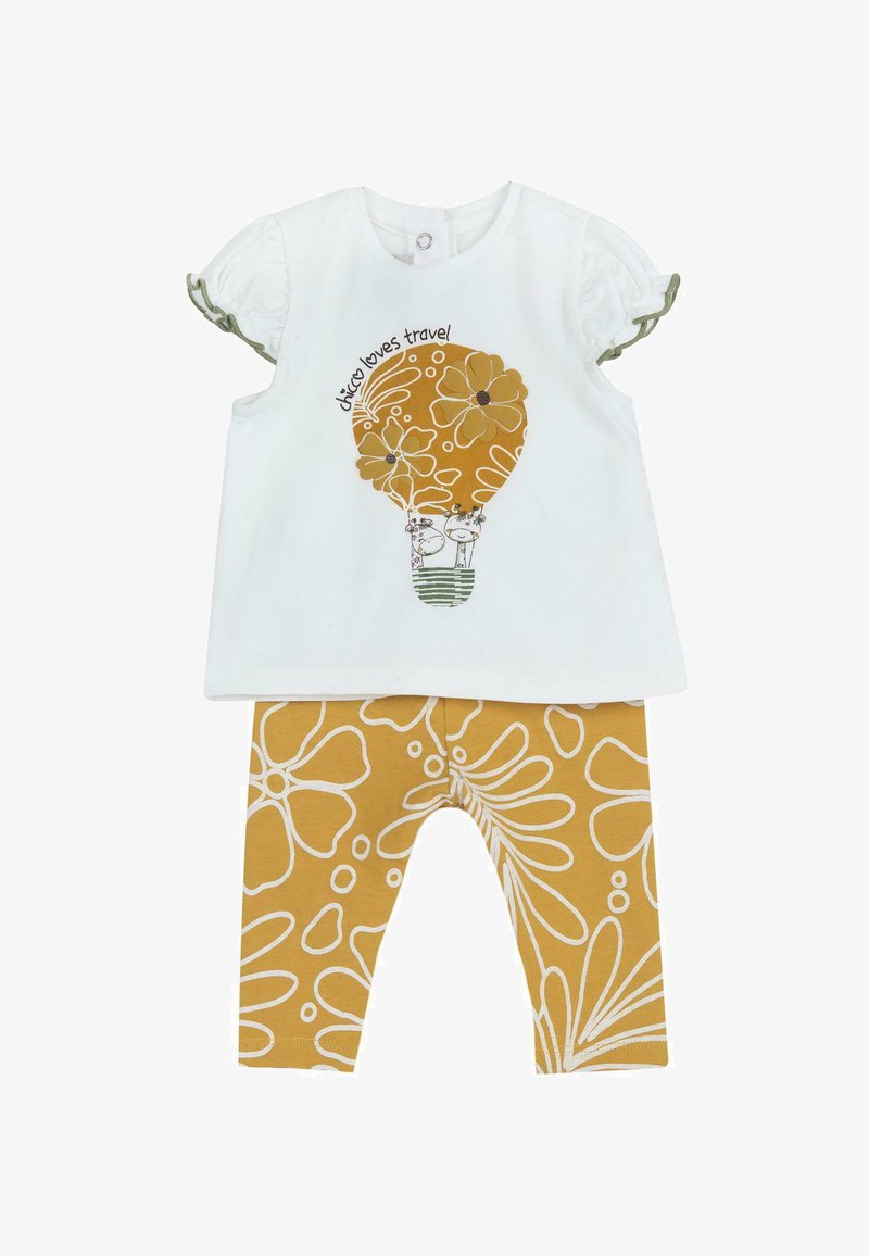 Haut blanc à manches courtes avec un graphique de montgolfière jaune et du texte, associé à des leggings moutarde ornés de motifs floraux blancs.