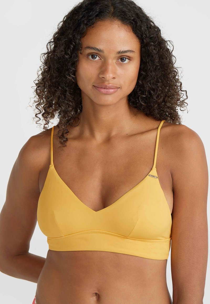 Sárga bralette sima textúrával, V-alakú dekoltázzsal és állítható vékony pántokkal. Egy kis logó díszítés található a váll közelében.