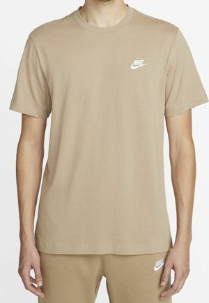 T-shirt beige à col rond en coton, avec manches courtes et logo Nike blanc sur le côté gauche de la poitrine. Texture lisse. Coupe décontractée.