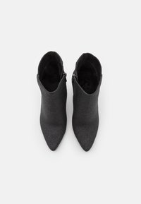 Schwarze Knöchelstiefel mit spitzem Schuhspitze, aus einem strukturierten Material gefertigt, mit einem seitlichen Reißverschluss und einem glatten Innenfutter.