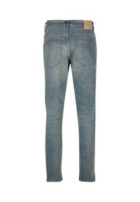 Světle modré džínové kalhoty s rovnými nohavicemi, které mají dvě zadní kapsy a štítek na pase ze světlého materiálu.