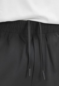 Pantaloni sportivi neri con vita elastica e cordino. Il materiale sembra liscio e ha una consistenza leggera.