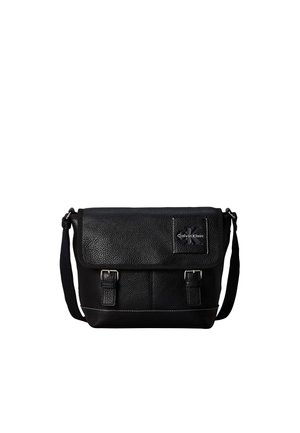 Sac messager en cuir noir Calvin Klein avec bandoulière réglable et rabat avant sécurisé par deux boucles.