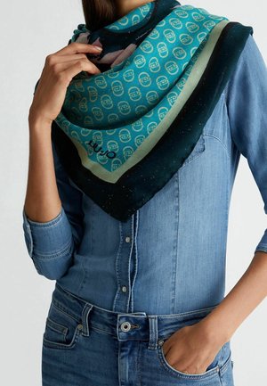 Écharpe en soie turquoise ornée d'un imprimé logo sur l'ensemble, bordée de rayures vert foncé et noires, présentant une texture douce et un subtil éclat.