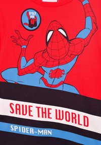 Czerwona koszulka z krótkim rękawem z grafiką Spider-Mana w niebiesko-czarnych kolorach, z napisem "URATUJ ŚWIAT" oraz okrągłym emblematem Spider-Mana. Materiał bawełniany.