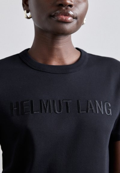 T-shirt de algodão preto com o texto bordado em relevo "HELMUT LANG" no peito, gola redonda e mangas curtas. Textura suave.
