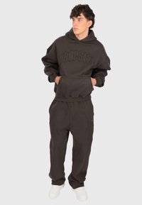 Felpa grigia scura con logo "DROPSIZE" in rilievo, tasca a marsupio e pantaloni della tuta abbinati con cuciture angolari e vestibilità comoda.