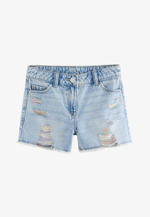 Ung pige iført en orange kort t-shirt, slidte lyseblå denimshorts og en leopardprint hårscrunchie i en knold.