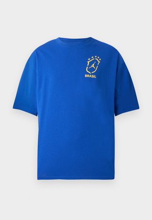 Zils īsroku krekls ar dzeltenu Brazīlijas emblēmu un piecām zvaigznēm kreisajā krūtīs.