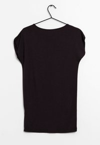 T-shirt nera a maniche corte su una gruccia, caratterizzata da una vestibilità morbida, scollatura tonda e una texture in cotone liscia. Design semplice, senza motivi o accenti.