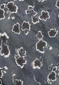 Blommönstrad tygprov i mörkblått med vita och grå blommönster. Har en mjuk textur och subtila blekningar i designen.