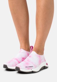 Růžové a bílé slip-on tenisky s tie-dye vzorem, vyrobené ze strečového materiálu, se bílou podrážkou a decentním logem.