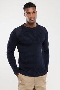 Granatowy sweter z prążkowanej dzianiny z długimi rękawami, z akcentami na ramionach z gładkiego materiału. Dopasowany krój z okrągłym dekoltem.