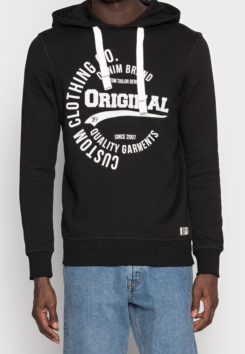 Felpa nera con stampa grafica bianca, cappuccio con coulisse e polsini a coste. Realizzata in tessuto morbido, presenta un'etichetta sull'orlo.