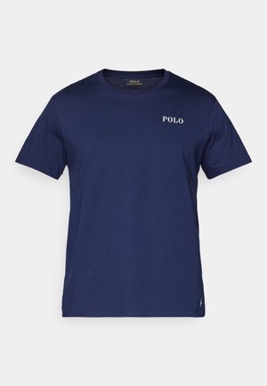 Marinblå t-skjorte laget av bomull, med rund hals og korte ermer. Den har en liten hvit "POLO" logo på brystet.