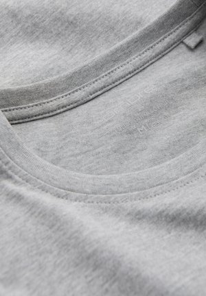Grå bomulds t-shirt med rund hals. Har en glat tekstur og synlig søm langs kraven og sømmene. Størrelsesmærket er delvist synligt.