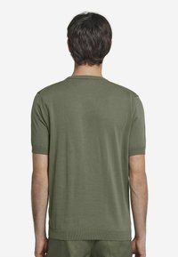 Olivgrön kortärmad tröja med rundad halsringning, slät textur och ribbade detaljer vid ärmarna och nederkanten.