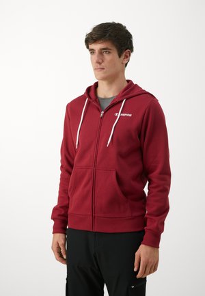 Red zip-up hoodie with a drawstring, front pockets, and a logo on the left chest. Fabric appears soft and textured, with ribbed cuffs.